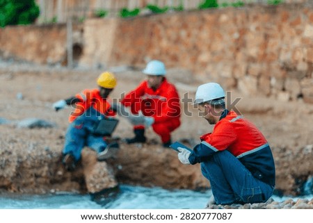 Engineers and technicians inspect a water source beside refinery drainage in the evening, supporting environmental monitoring, safety compliance, and industrial risk control.