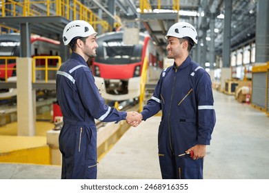 Engineers or technicians shaking hands before starting work at train construction site