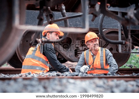 Engineers under discussion inspection and checking construction process railway switch and checking work on railroad station .Engineer wearing safety uniform and safety helmet in work.