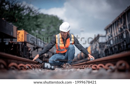 Engineers under inspection and checking construction used tape measure railway switch and checking work on railroad station by radio communication.Engineer wearing safety uniform and safety helmet.