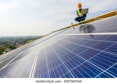 Engineers Use A Laptop Computer To Examine The Solar Panels On The Roof Of A House Where The Solar Panels Are Installed Using Solar Energy.