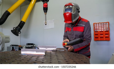 Engineers Use A Wireless Remote Control Of Robotic Welding And Robot Gripping Working On Smart Factory.