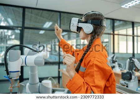 Engineers are using virtual AR to maintain and check the work of human robot in the 4.0 smart factory,Industrial robot programming software for automated manufacturing technology.