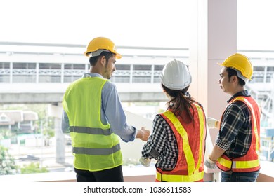 Engineers Visit The Construction Site.Examining Blueprint With Construction Manager.