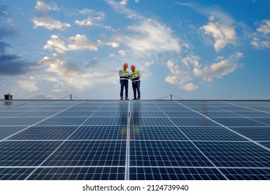 Ingenieure, die auf dem Dach sind, prüfen und prüfen Solarzellenpanel mit Laderampe und Funkkommunikation, Solarzellen sind intelligente Gitterökologie Energie Sonnenlicht alternative Kraftwerkskonzepte.