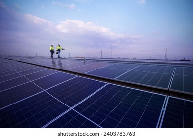 Engineers walking on roof inspect and check solar cell panel by hold equipment box and radio communication ,solar cell is smart grid ecology energy. - Powered by Shutterstock