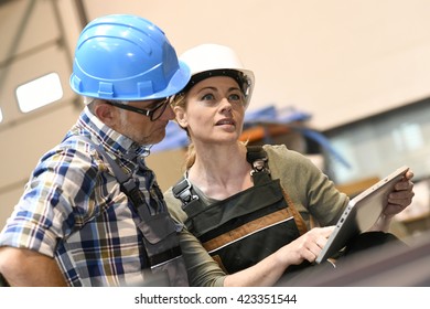 Engineers in warehouse checking stock with tablet