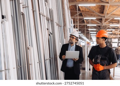 Engineers and worker checking window frame samples in a production or showroom facility, discussing product quality and selection