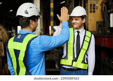 engineers or workers giving high five each other after success work and project at construction site