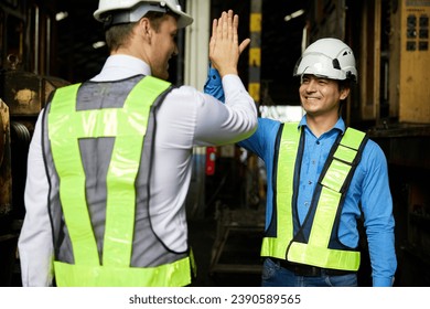 engineers or workers giving high five each other after success work and project at construction site