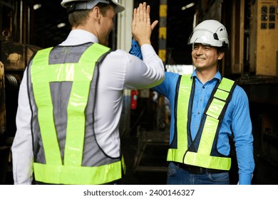 engineers or workers giving high five each other after success work and project at construction site