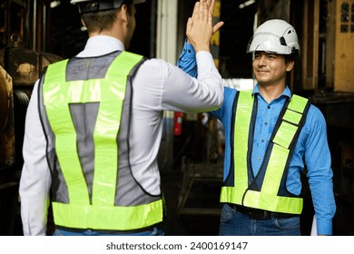 engineers or workers giving high five each other after success work and project at construction site