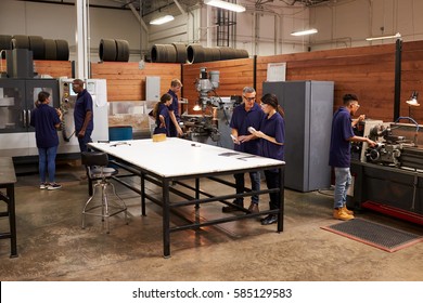 Engineers Working On Machines In Busy Metal Workshop - Powered by Shutterstock