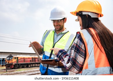 Engineers Working On Railway Train Statation And Holding Laptop For Plan And Meeting. Portrait Of Professional Leadership Of Engineering Teamwork. Warehouse And Successful Concept. 