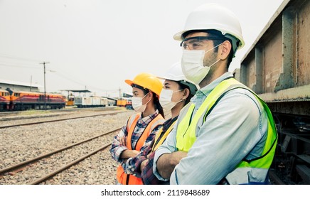 Engineers Working On Railway Train Statation And Holding Laptop For Plan And Meeting. Portrait Of Professional Leadership Of Engineering Teamwork. Warehouse And Protect COVID-19 Concept. 