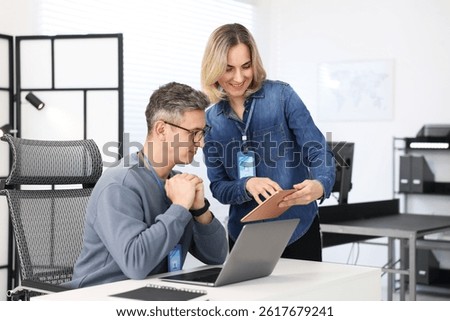 Engineers working together with devices at table in office