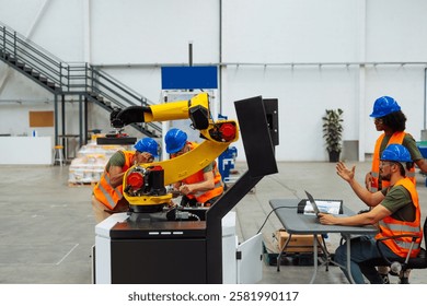 Engineers working together programming and maintaining a robotic arm in modern factory