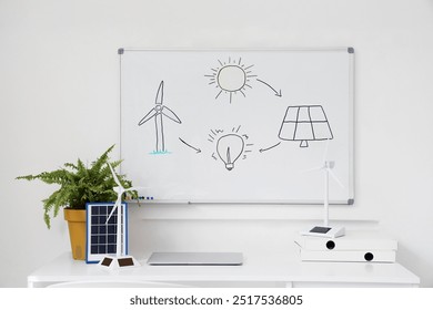 Engineer's workplace with wind turbine models and whiteboard in office