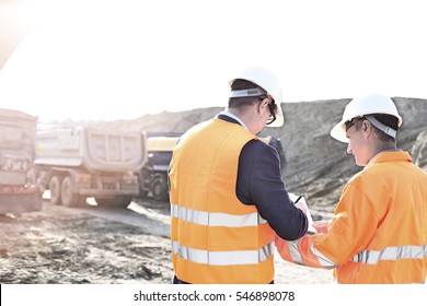 Engineers writing on clipboard at construction site against clear sky - Powered by Shutterstock