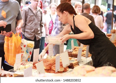 England, Manchester, Bolton: August 2019 - Bolton Food And Drink Festival On August Bank Holiday Weekend. A Lady On A Dessert Stall Serving Pastry.