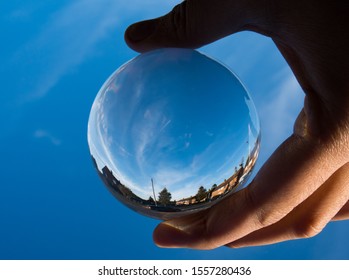 England UK - 10 Nov 2019:  Crystal Ball Photo Of Surrounding Houses And Tiny Plane With Vapour Trail In Blue Sky.