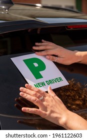 England, UK. 2021.  New Driver, Young Attractive Woman Holding A Green New Driver Sign To Display On Her Car After Passing The Driving Test.