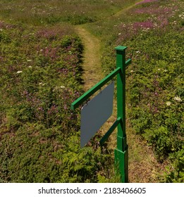 England, UK. 2022. Footpath And Signpost Leading Through A Field Of Wild Flowers In The English Countryside.