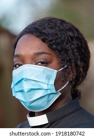 England, UK, December 2020. A Black Minister Wearing A Protective Medical Mask And White Collar During Coronavirus Outbreak