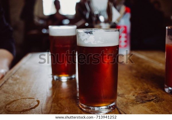 An english ale bitter beer pint on a wooden table in a\
pub in UK