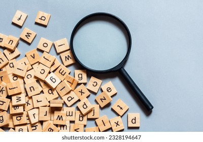 English alphabet made of square wooden tiles with the English alphabet scattered on blue background. The concept of thinking development, grammar.