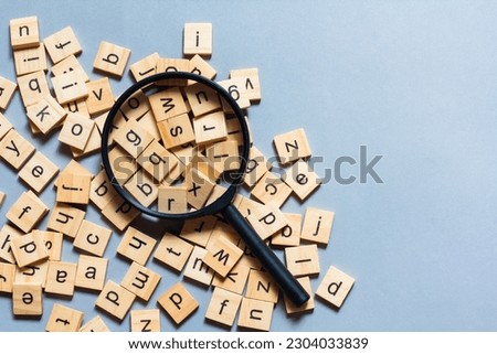 English alphabet made of square wooden tiles with the English alphabet scattered on blue background. The concept of thinking development,grammar.