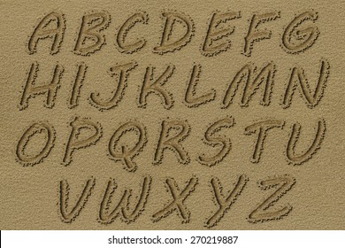 English alphabet written on a beach sand.