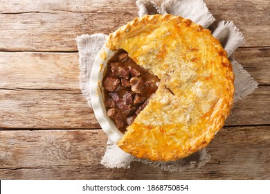 English Beef Steak Pie With Crispy Puff Pastry Close-up In A Baking Dish On The Table. Horizontal Top View From Above
