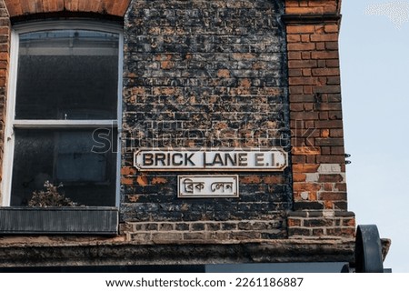 English and Bengali bilingual street name sign on a building in Brick Lane, London, UK.