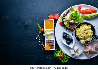 English Breakfast. Eggs, Olives, Fresh Vegetables, Nuts, Dried Fruit And Honey. Top View. Free Space For Text. On A Wooden Background.