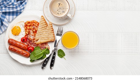 English Breakfast With Fried Eggs, Beans, Bacon And Sausages. Coffee And Orange Juice. Top View Flat Lay With Copy Space