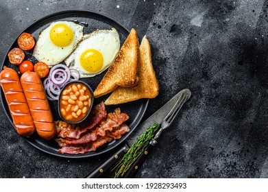 English Breakfast With Fried Eggs, Sausages, Bacon, Beans And Toasts In A Plate. Black Background. Top View. Copy Space.