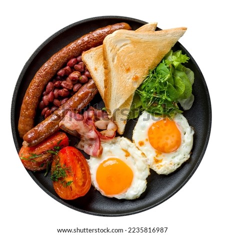 English Breakfast with two eggs, sausage, bacon, toasts and vegetables, red beans on a black plate top view isolated on white background