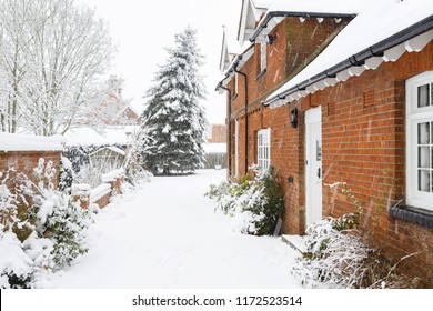 English Country Home In Winter With A Driveway Covered In Snow