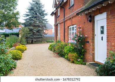 English country house and garden in Autumn with a gravel driveway. The house is Victorian period, with flower borders filled with shrubs and perennials - Shutterstock ID 1678312792