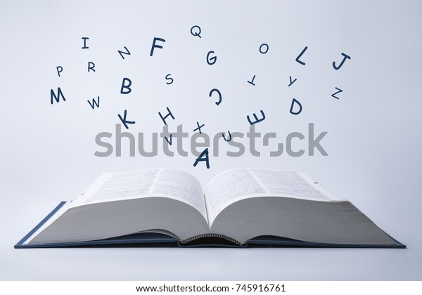 English dictionary with letters flying out of\
it on a white\
background.