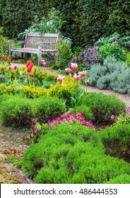 English Garden With A Walk Path Leading To Empty Bench 