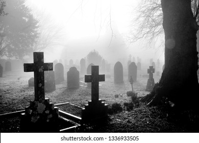 An english grave yard in the mist, in the foreground the head stones are in the shape of Christian crosses the head stones become more shrowded in mist and fog a distant dark shape of the church