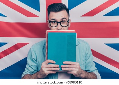 English language learning concept-portrait of excited man holding colorful copy books in hands closing half face with notebooks standing over English flag background - Shutterstock ID 768980110