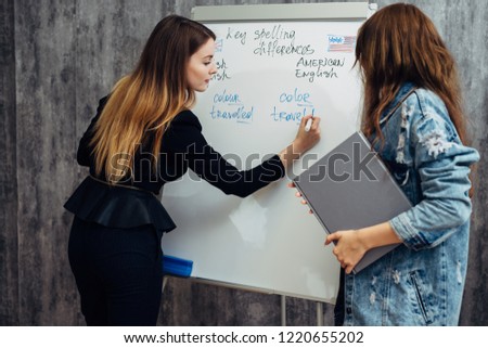 English language school. Two female students talking in classroom.