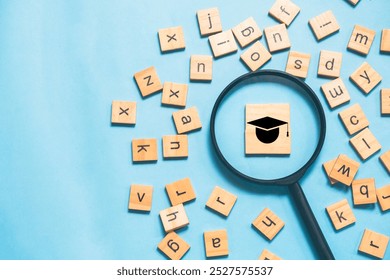 An English learning concept featuring scattered English letters with a magnifying glass highlighting a graduation cap icon - Powered by Shutterstock