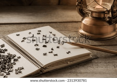 English letters are scattered on the notepad page for notes, the concept of grammar, languages, creativity and ideas for a story