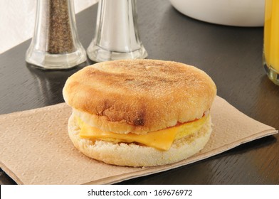 An English Muffin With Ham, Egg, Cheese And A Glass Of Orange Juice