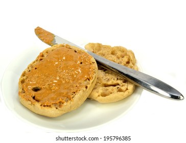 English Muffin With Peanut Butter And A Knife On A White Background.