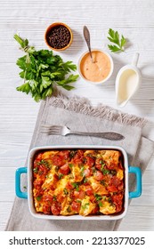 English Muffin Sausage Breakfast Casserole In Baking Dish On White Wooden Table With Ingredients, Vertical View From Above